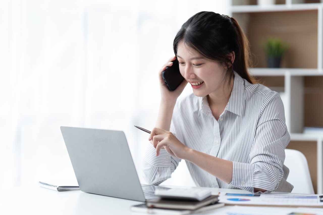 asian-businesswoman-in-formal-suit-in-office-happy-and-cheerful-during-using-smartphone-and-working-.jpg